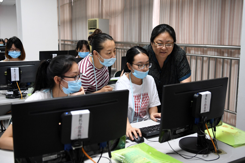 7月12日，在西南大学高考评卷现场，教师们在进行探讨。