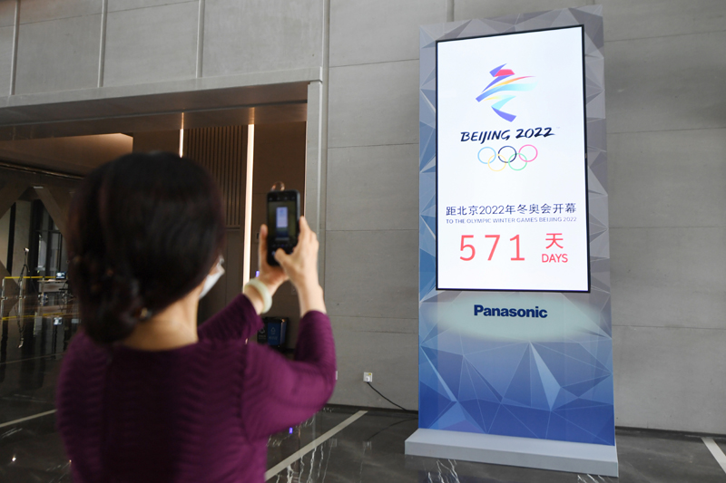 7月13日，一位参观者在北京冬奥组委首钢办公区拍摄北京2022年冬奥会倒计时装置。