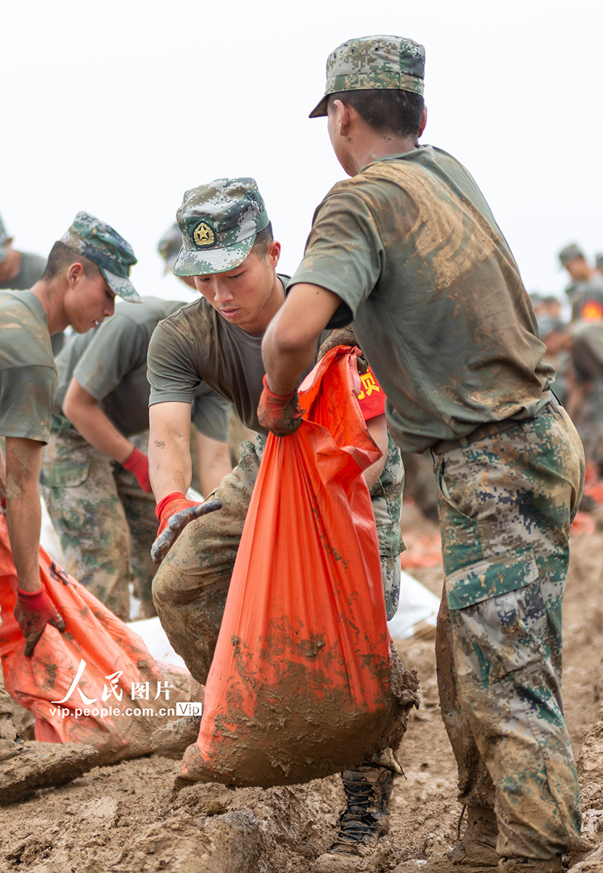 2020年7月14日，安徽省銅陵市郊區陳瑤湖鎮橫埠河南堤，東部戰區陸軍某旅官兵在搬運沙袋。