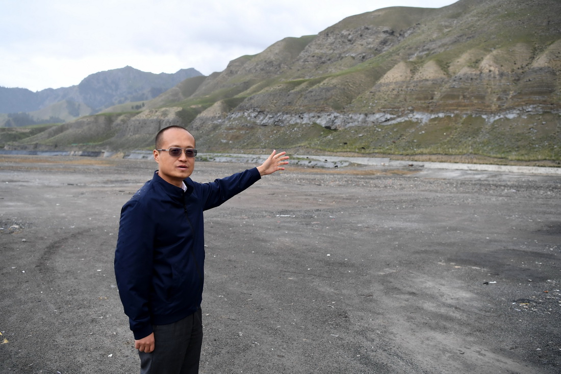 7月16日，烏魯木齊市生態環境局烏魯木齊縣分局局長嚴偉濤介紹一家企業的礦坑被回填的情況。新華社記者沙達提攝