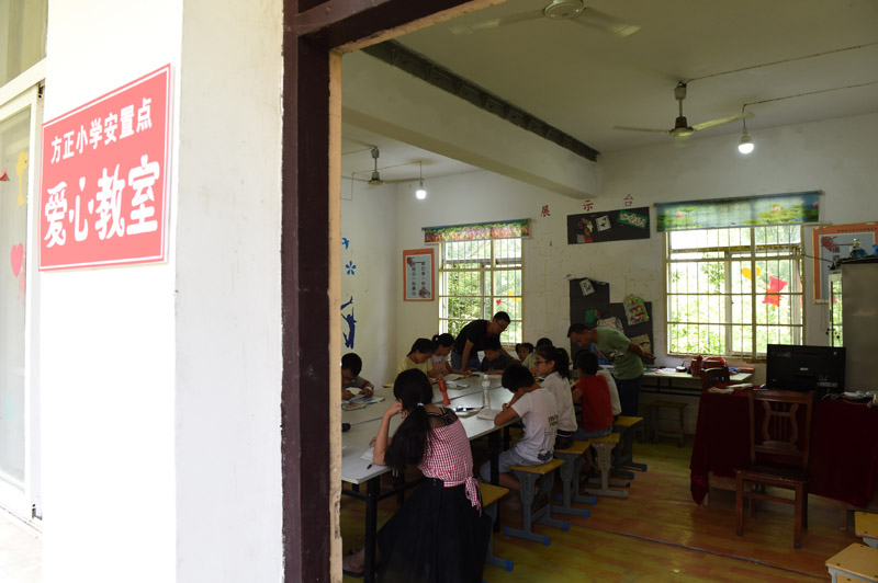 7月22日，在樅陽縣橫埠鎮方正小學安置點，小朋友們在“愛心教室”裡看書寫作業。