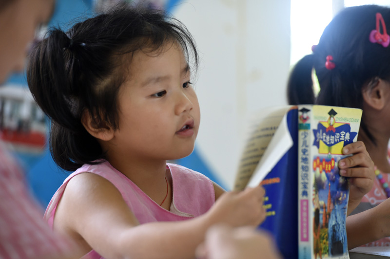 7月22日，在樅陽縣橫埠鎮方正小學安置點，小朋友在“愛心教室”裡看書。