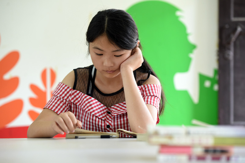 7月22日，在樅陽縣橫埠鎮方正小學安置點，小朋友在“愛心教室”裡看書。