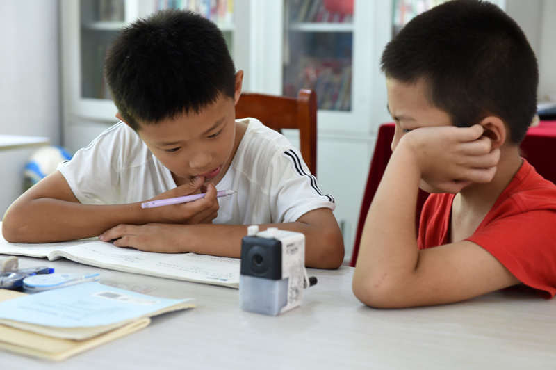 7月22日，在樅陽縣橫埠鎮方正小學安置點，小朋友在“愛心教室”裡寫暑假作業。