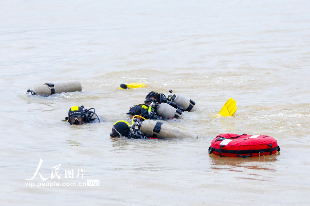 7月30日，在涪江四川省遂寧段江面上，消防潛水員潛入江中進行水下救援演練。劉昌鬆/人民圖片