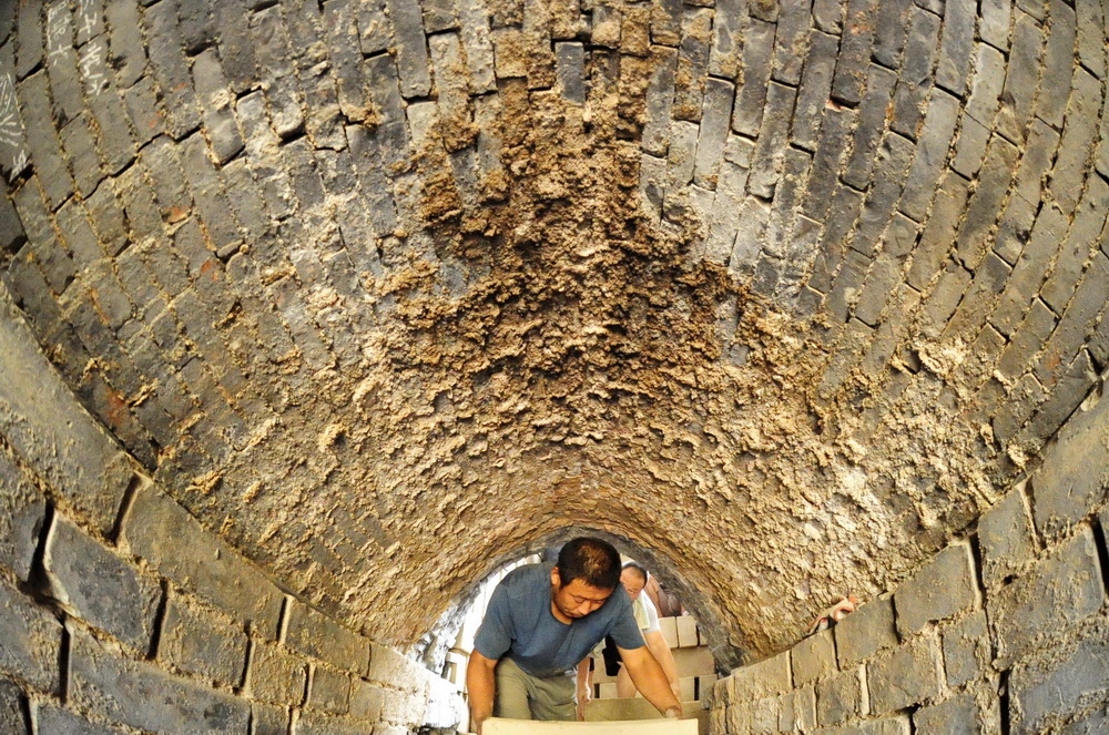 7月30日，河北省任丘市出岸鎮古建磚廠工人將磚坯裝窯以備燒制。