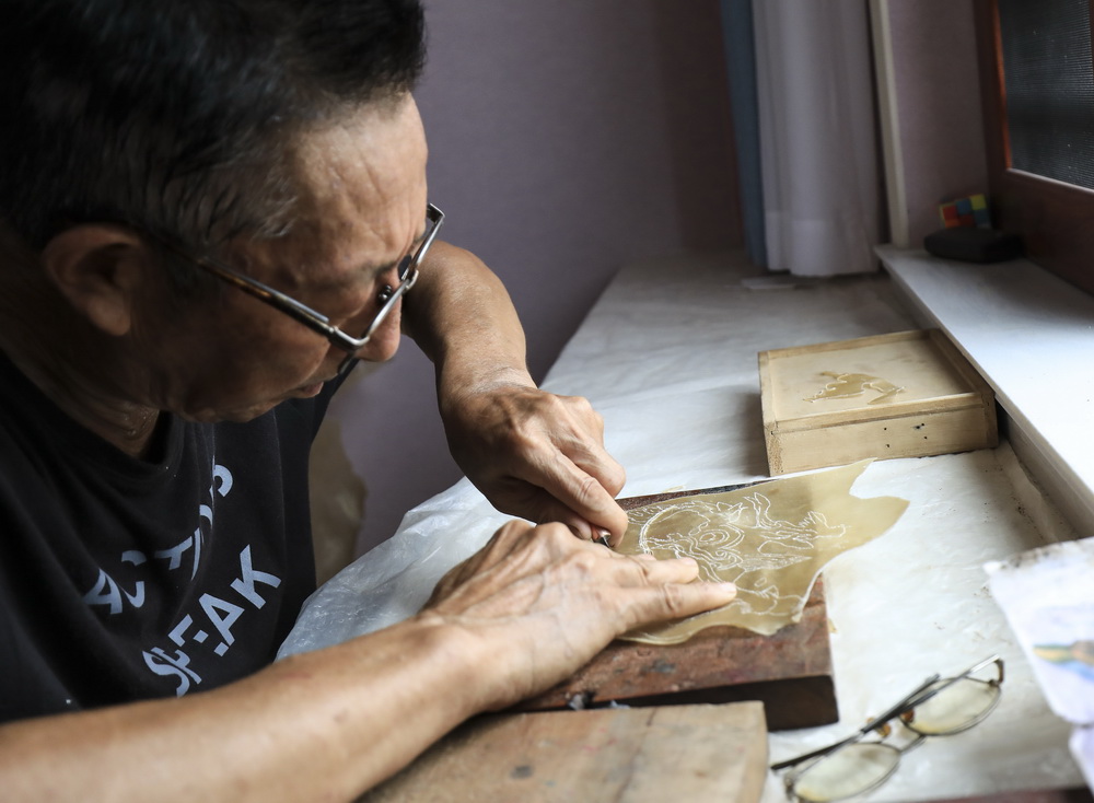  8月1日，皮影藝人蔡善存在家中雕刻制作皮影。
