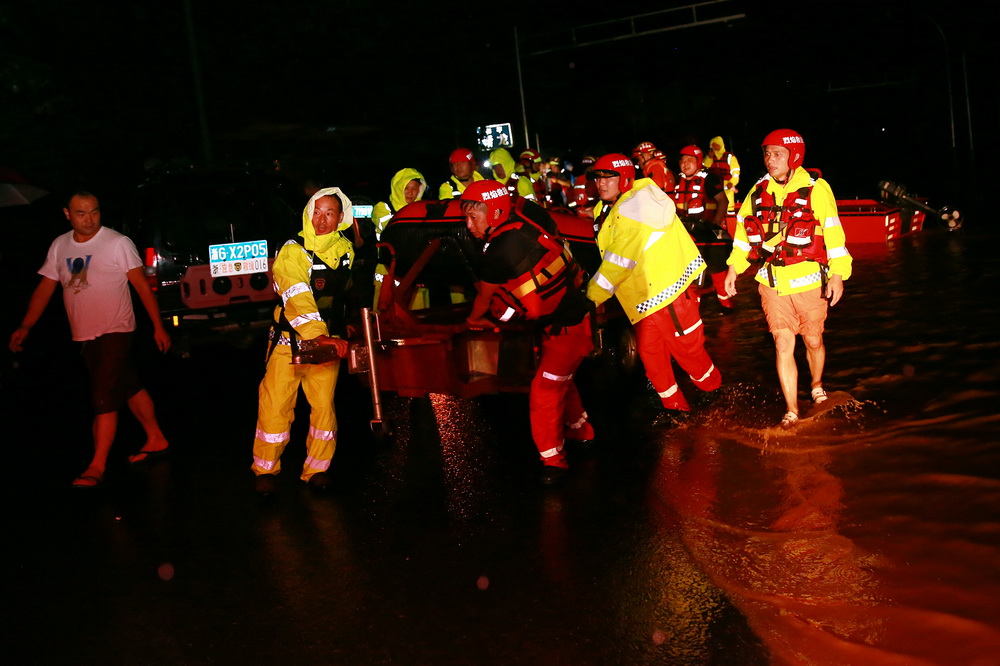 8月4日夜晚，浙江省東陽市南馬鎮雅村村，受台風“黑格比”影響，該村許多地方被雨水淹沒，救援隊員用皮劃艇救助需要轉移的村民。