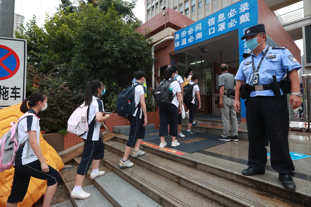 8月10日，在位於武漢的湖北省水果湖一中，工作人員引導復學的初一、初二年級學生入校。