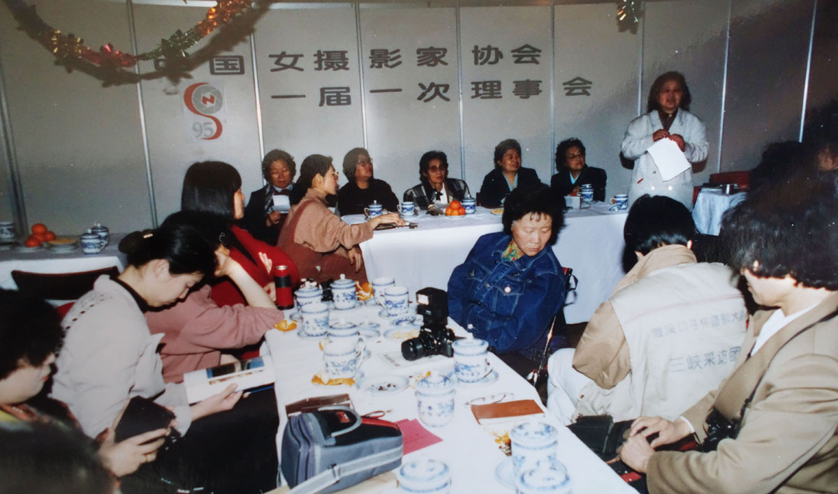 1995年4月18日，沈英（照片中藍衣者）參加中國女攝影家協會第一屆一次理事會。