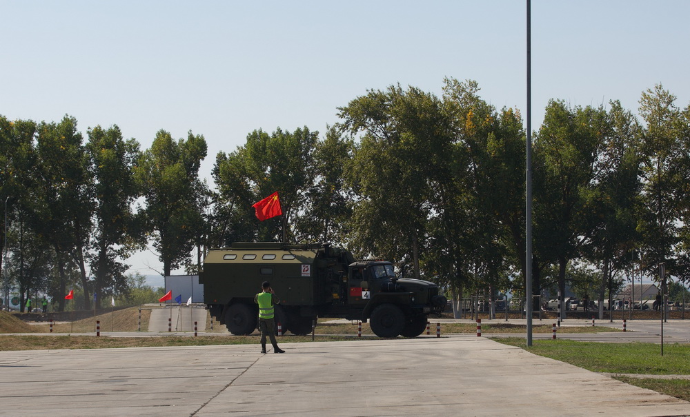 8月25日，在俄羅斯沃羅涅日州1437初級汽車裝甲訓練中心舉行的“汽車能手”項目修理車組比賽中，中國參賽官兵駕駛修理車通過障礙路段。新華社發（王世民 攝）