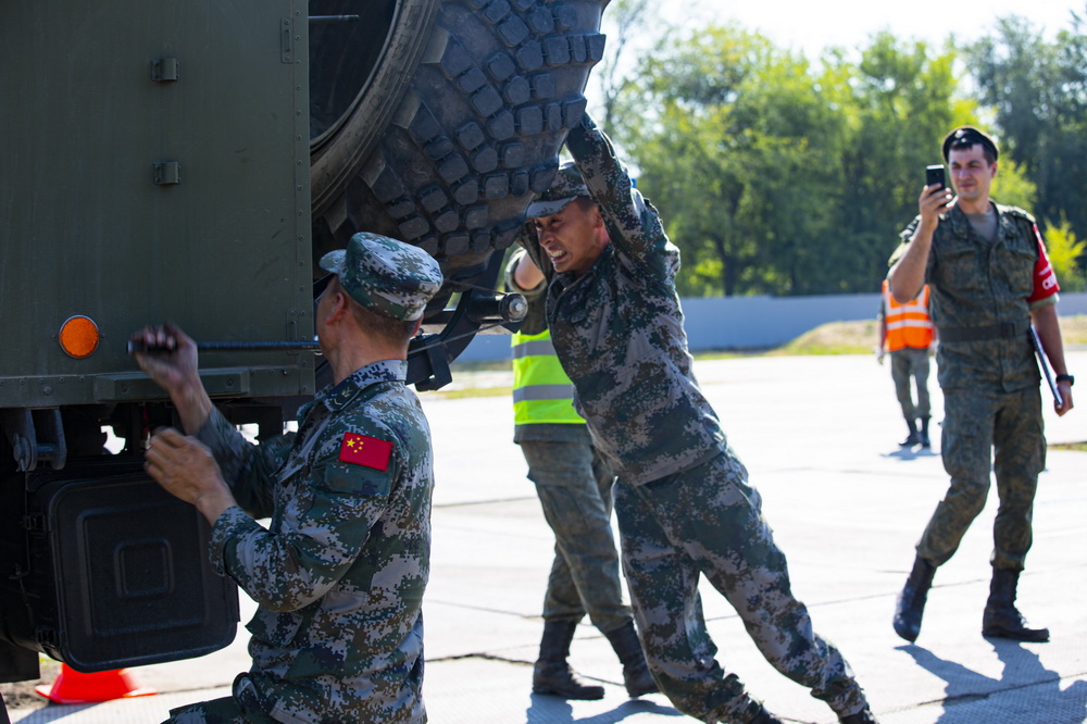  8月25日，在俄羅斯沃羅涅日州1437初級汽車裝甲訓練中心舉行的“汽車能手”項目修理車組比賽中，中國參賽官兵進行輪胎更換作業。新華社發（王世民 攝）
