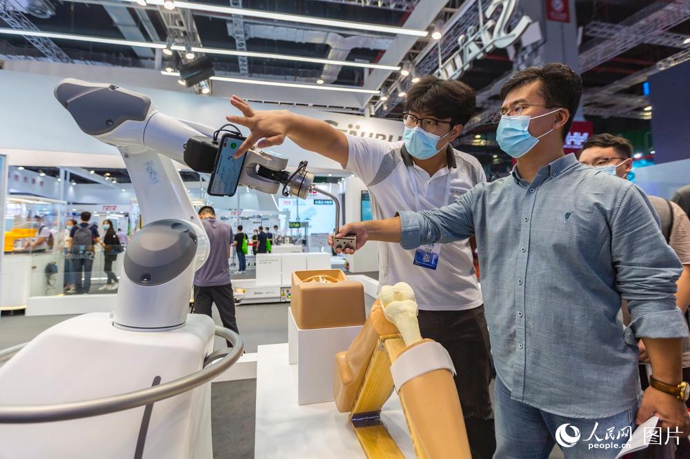 9月15日，观众在第二十二届中国国际工业博览会上了解手术机器人。王初/摄