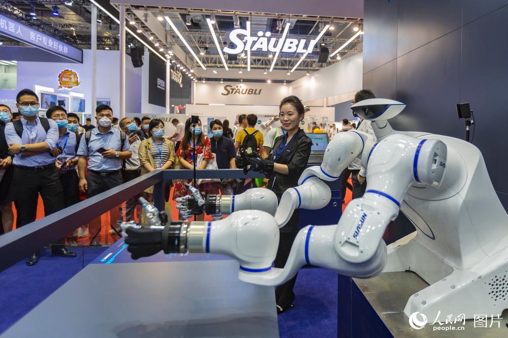 9月15日，工作人员正在第二十二届中国国际工业博览会现场向观众演示雄克5指机械手。王初/摄