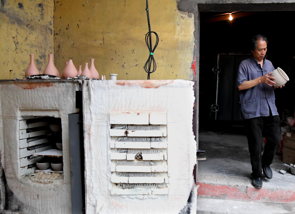 在河南省鞏義市站街鎮小黃冶村的工作室裡，游光明在裝窯（6月19日攝）。新華社記者 李安 攝