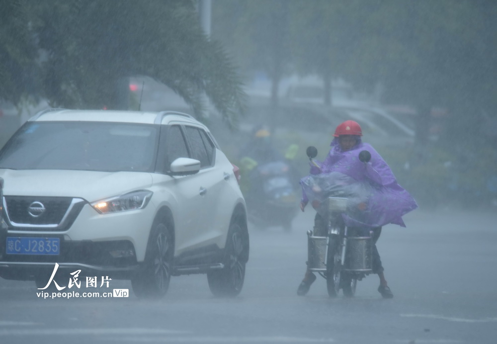 2020年9月18日，海南琼海，市民在暴雨中出行。