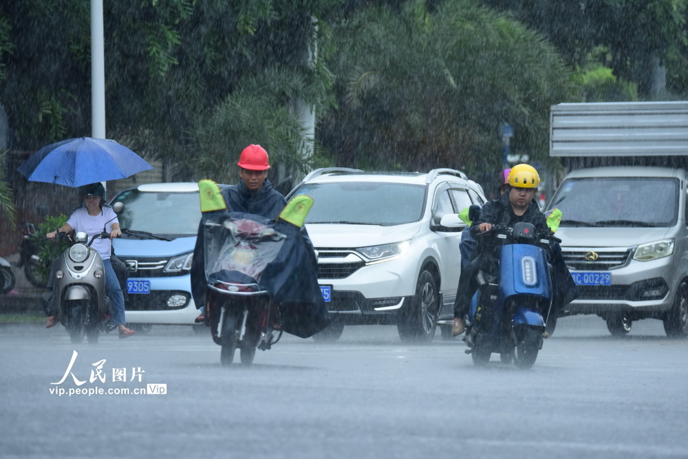 2020年9月18日，海南琼海，市民在暴雨中出行。