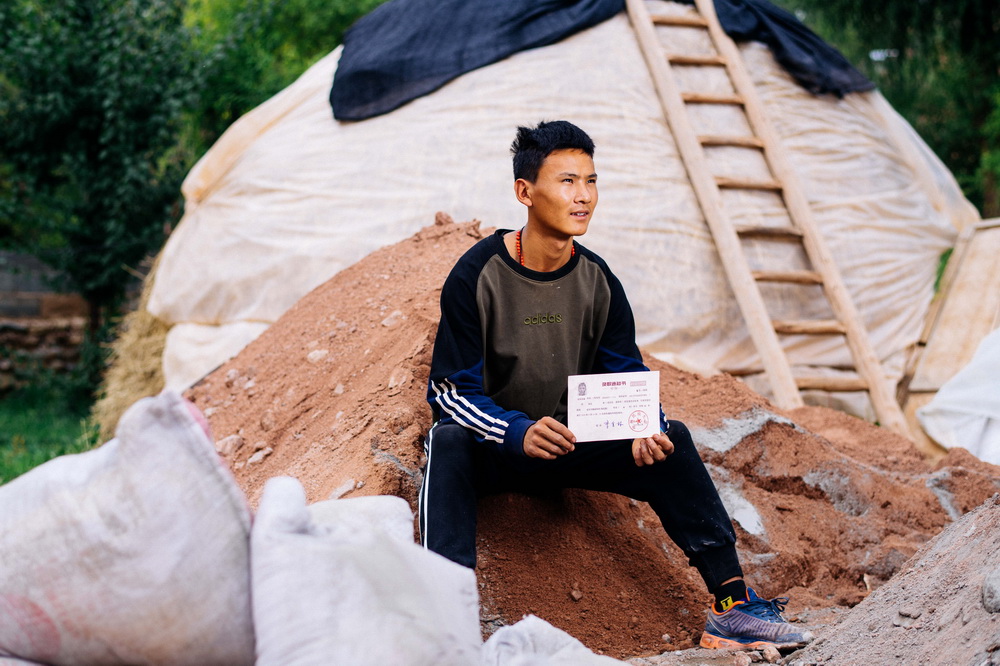 9月12日，在青海省化隆回族自治县金源藏族乡科上村，拉毛东智展示自己的大学录取通知书。
