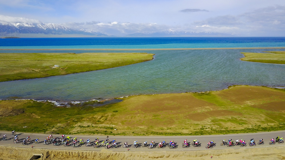 參與環賽裡木湖自行車賽的騎手們騎行在賽裡木湖畔公路上（2017年5月31日攝，無人機照片）。新華社記者 胡虎虎 攝