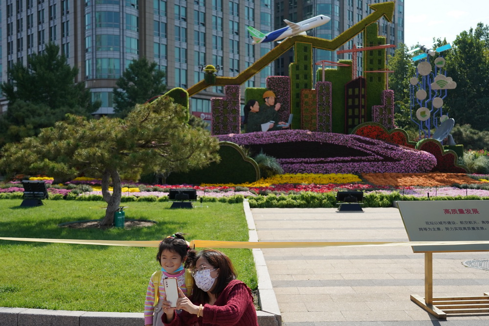 9月30日，游客在東單路口的“高質量發展”花壇前參觀。