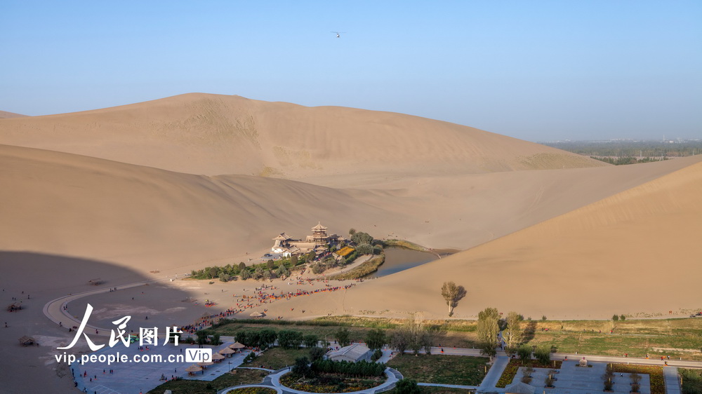 2020年10月7日，在甘肃省酒泉地区敦煌市鸣沙山月牙泉风景区，游客们游览月牙泉风光。