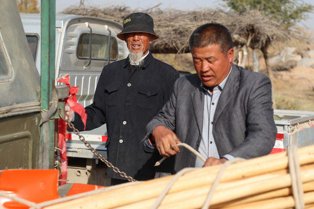 在武威市凉州区长城镇红水村，王天昌（左）和儿子王银吉准备工具前往林区干活（10月23日摄）。