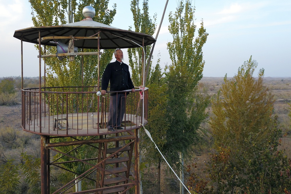 在武威市凉州区长城镇红水村，王天昌在防火塔上瞭望林区（10月23日摄，无人机照片）。
