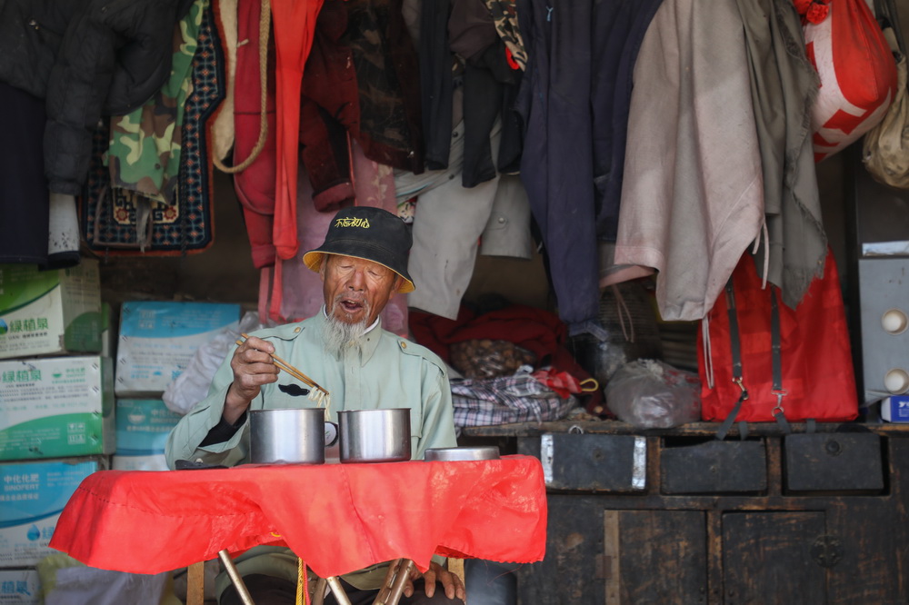 在武威市凉州区长城镇红水村治沙住地，王天昌吃午饭（10月23日摄）。