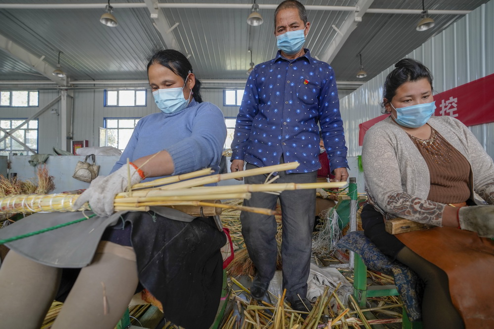 在墨玉县阿克萨拉依乡乌尊艾日克村佳美扫把制作中心，当地村民在制作扫把（10月22日摄）。