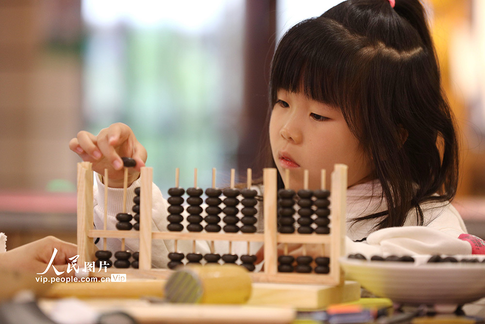 11月14日，浙江嘉兴，小朋友们正在专心致志的制作算盘。
