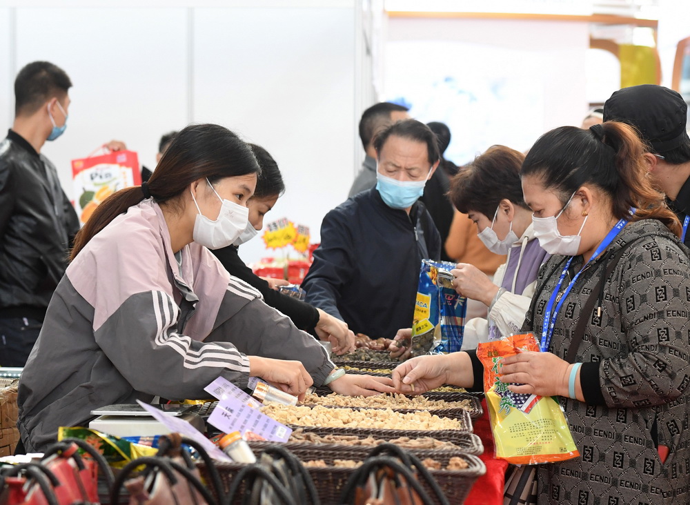 11月30日，在南宁国际会展中心，观众（右）在选购商品。新华社记者 陆波岸 摄