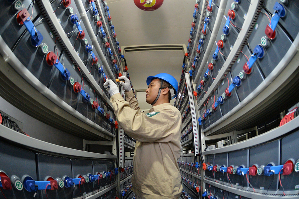 在江蘇省灌雲縣開山島，國家電網的施工人員在調試“風光儲互補智能微電網系統”的蓄電池組（2019年6月18日攝）。新華社發（萬程鵬 攝）