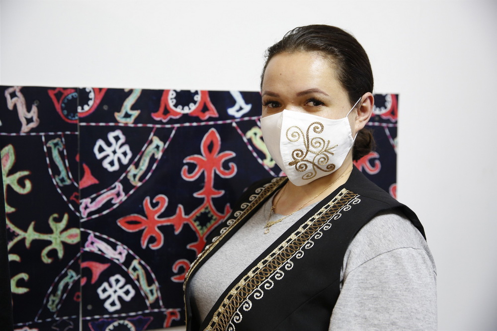 12月9日，在吉爾吉斯斯坦首都比什凱克市，一名女性展示吉“民族風”口罩。