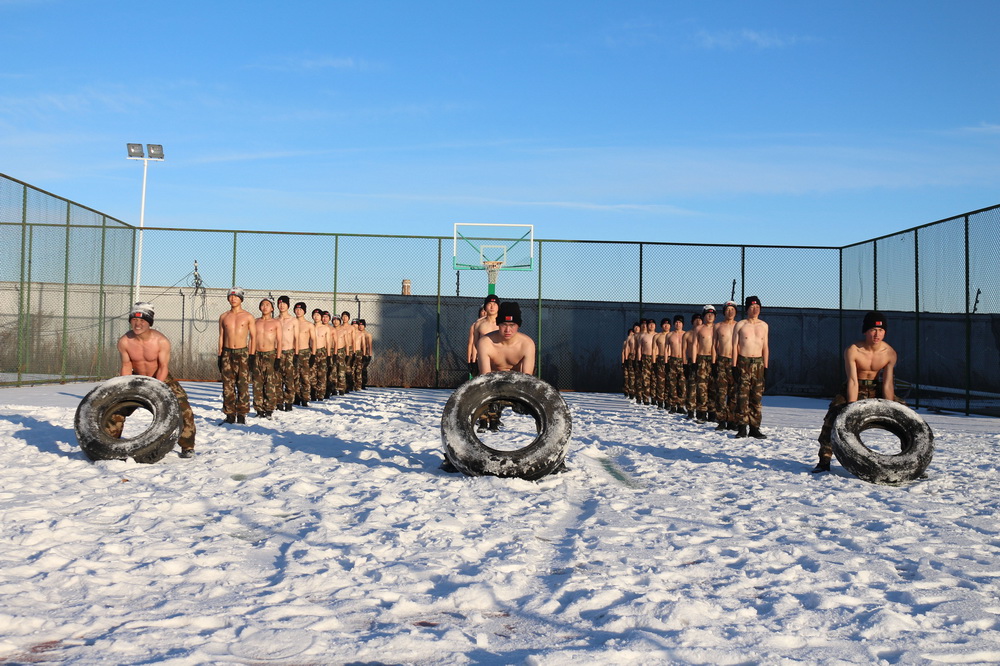 武警黑龍江總隊黑河支隊官兵冒著零下20攝氏度嚴寒在雪中開展翻輪胎訓練（12月10日攝）。新華社發（李響 攝）