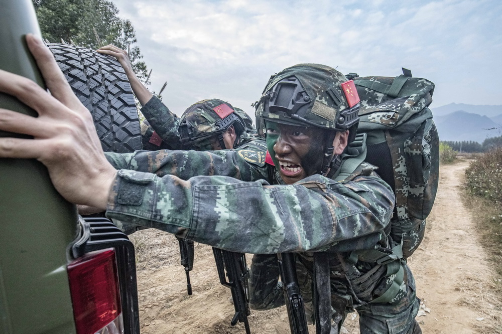武警廣西總隊貴港支隊官兵在野外進行坡地推車訓練（12月14日攝）。新華社發（余海洋 攝）