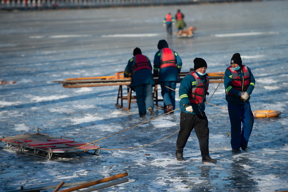 12月13日，工人在北京什刹海景区结冰的湖面上搭建围挡。新华社记者 陈钟昊 摄
