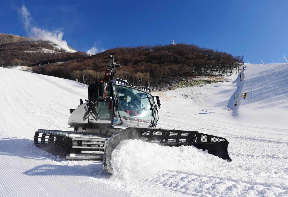 12月29日，工作人員在國家高山滑雪中心雪道上操作壓雪車。