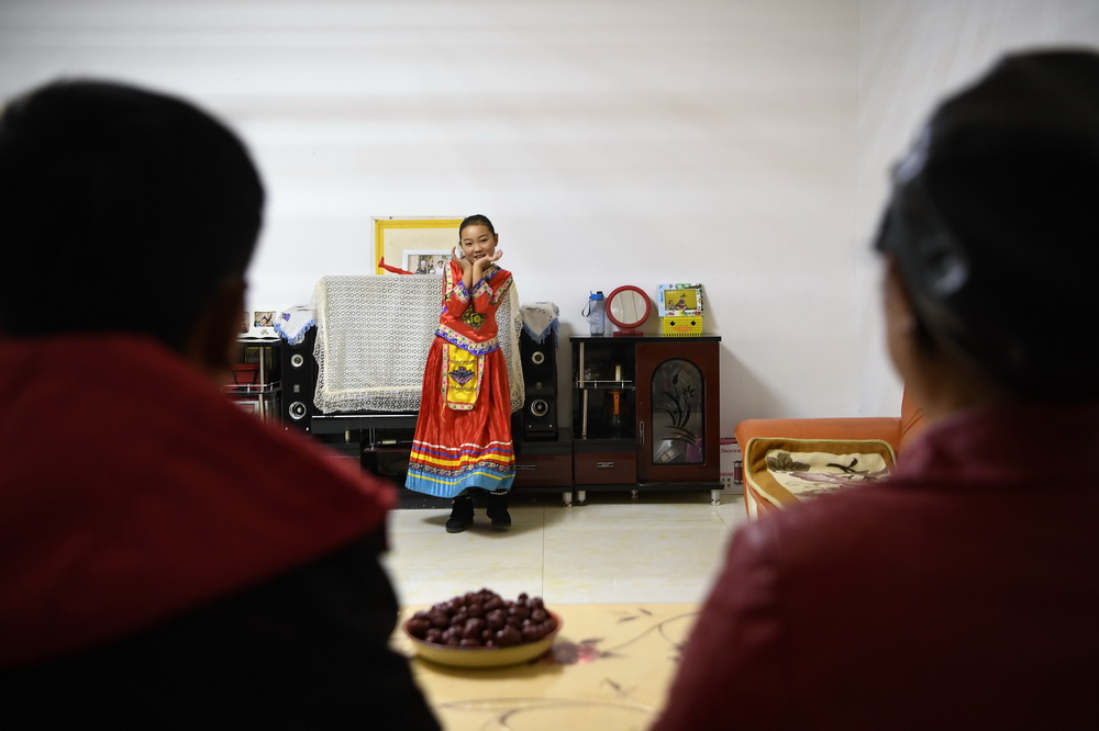 擺西彥（右）在家中看女兒跳舞（11月10日攝）。新華社記者 楊植森 攝