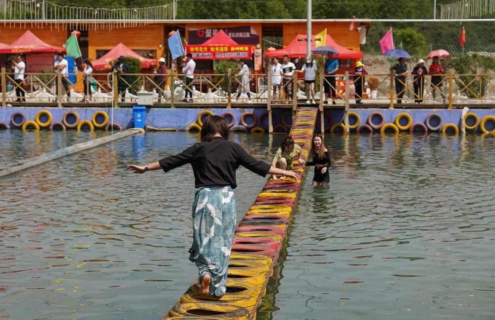 6月9日，游客在青海卓扎灘原生態景區的水上吊橋項目玩耍。新華社記者 吳剛 攝
