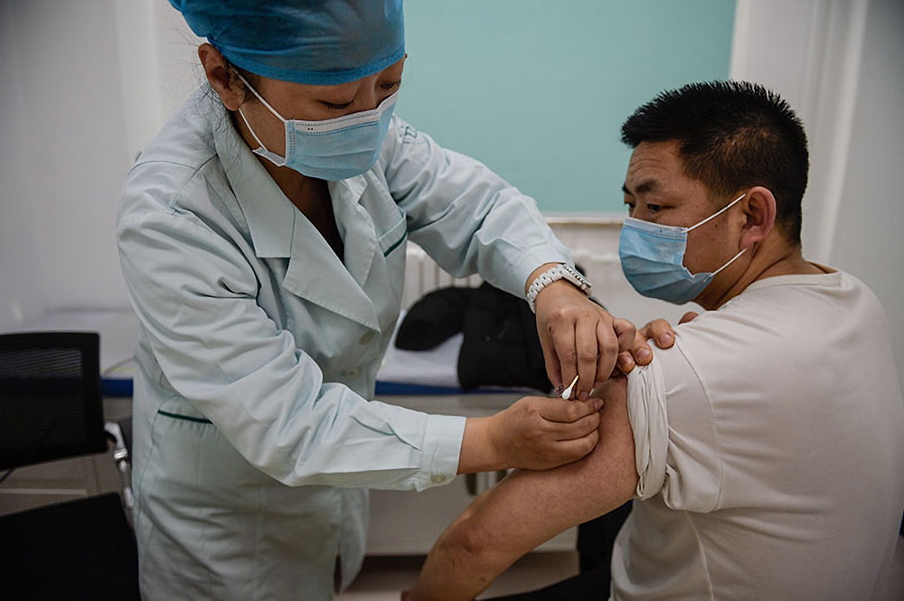 2021年1月2日，在北京市朝陽區太陽宮社區衛生服務中心，醫護人員為接種人員注射疫苗。新華社記者 彭子洋 攝