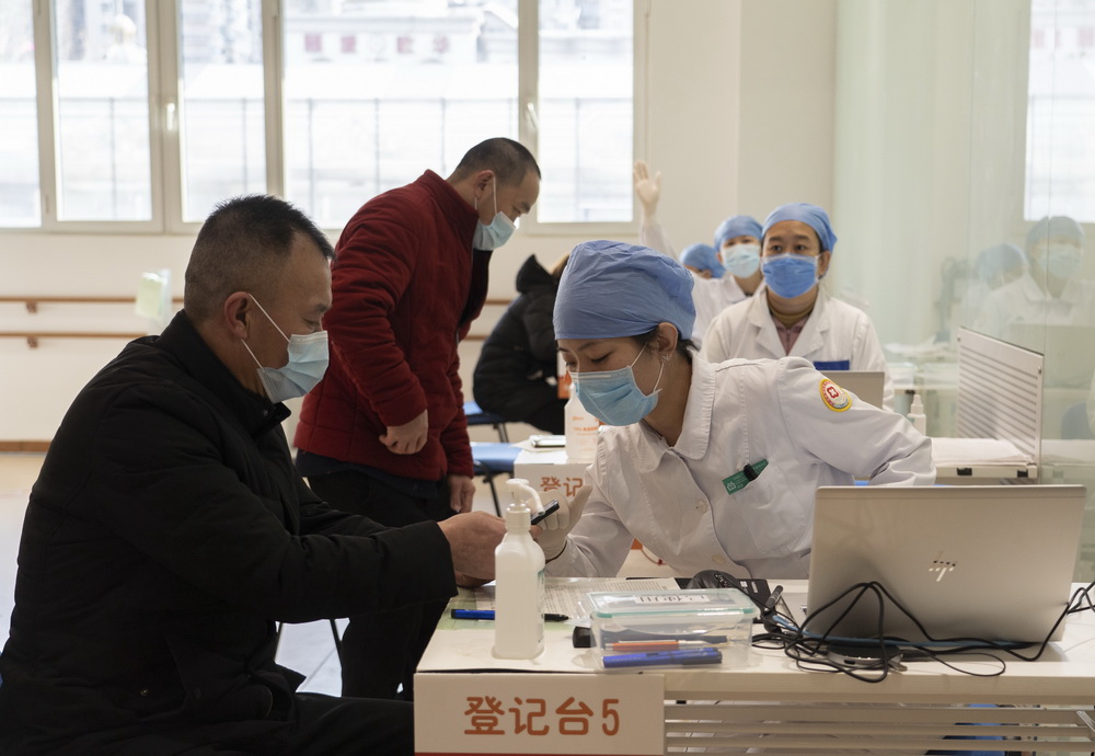 2021年1月3日，在位于北京市西城区广安门外街道红莲社区卫生服务站的接种点，医护人员为接种人员进行接种前登记。新华社记者 李梦馨 摄
