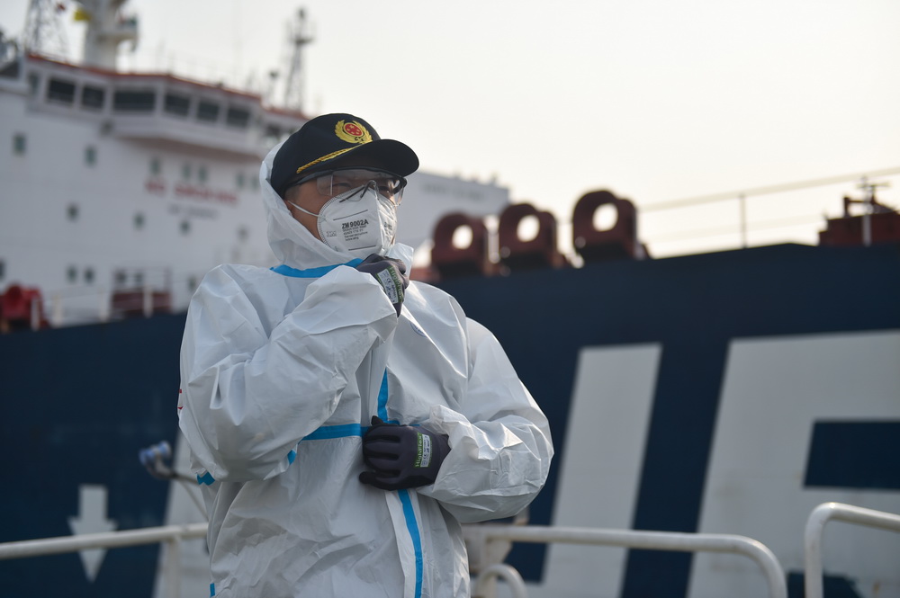 2020年12月28日，天津港引航中心引航員李佔濤在登上一艘船舶前穿上防護服。