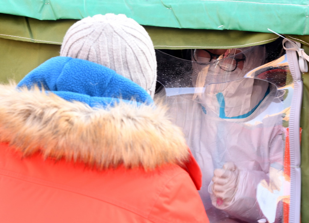 在北京市顺义区双丰街道香悦西区采样点，医护人员为被检测人员采集核酸样本（1月3日摄）。新华社记者 任超 摄