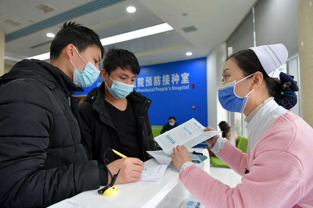 2021年1月4日，在江西省人民醫院紅谷灘院區，護士向人們介紹接種新冠疫苗的相關注意事項。