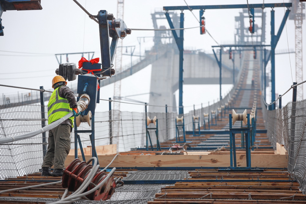 1月5日，一名建設者在開州湖特大橋建設工地進行主纜索股架設。