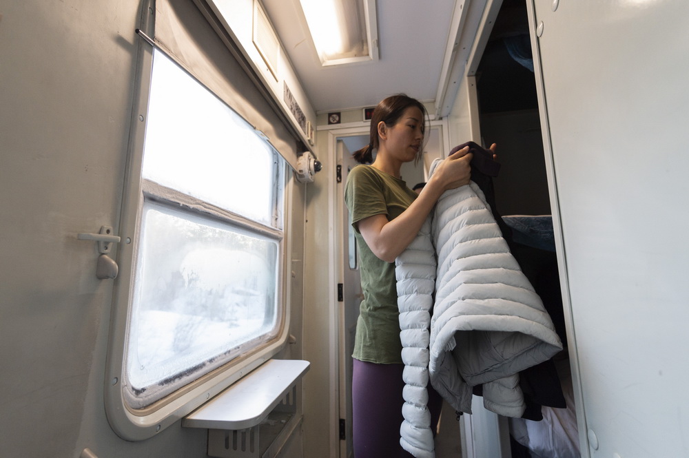 2021年1月7日，在K7039次列車上，旅客在准備下車時要穿的衣服。