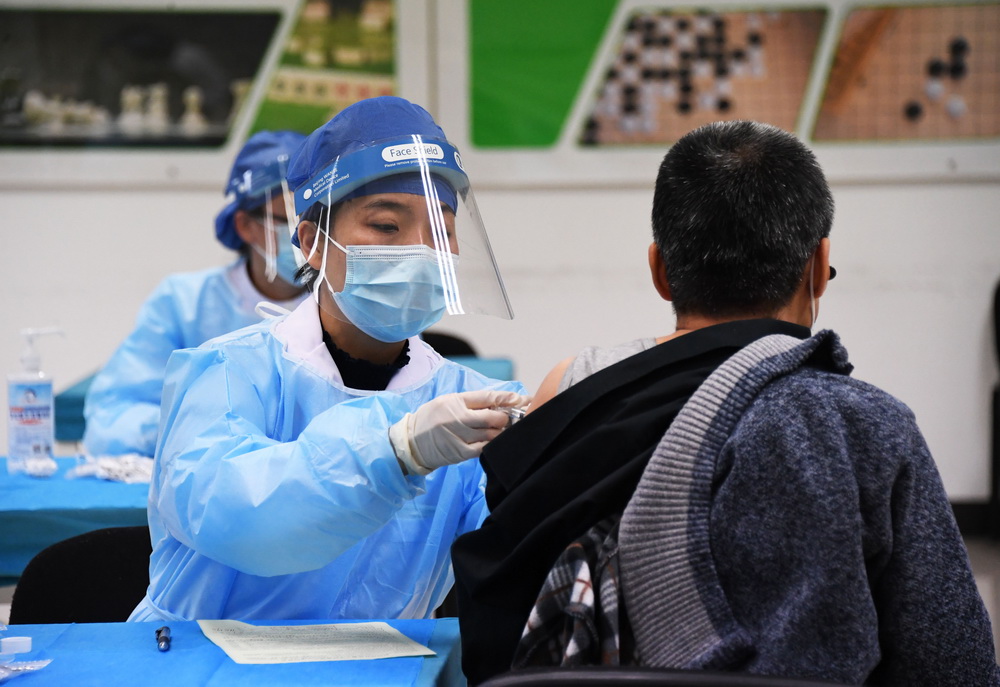 1月11日，在北京市海淀区学院路街道的一处临时新冠疫苗接种点，医务人员为接种人员接种新冠疫苗。新华社记者 任超 摄