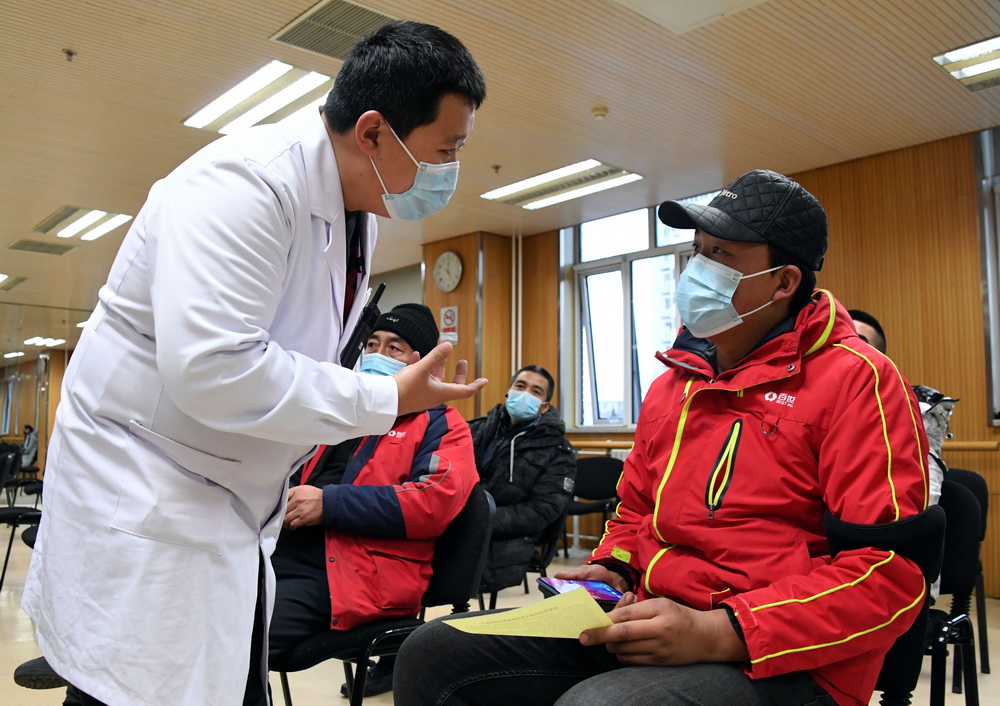 1月11日，在北京市海淀区学院路街道的一处临时新冠疫苗接种点，医务人员了解留观区人员在接种疫苗后的身体情况。新华社记者 任超 摄