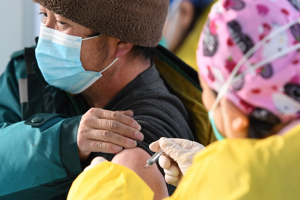 在北京市海淀区中关村街道临时集中接种点，医务人员为接种人员注射新冠疫苗（1月6日摄）。新华社记者 鞠焕宗 摄