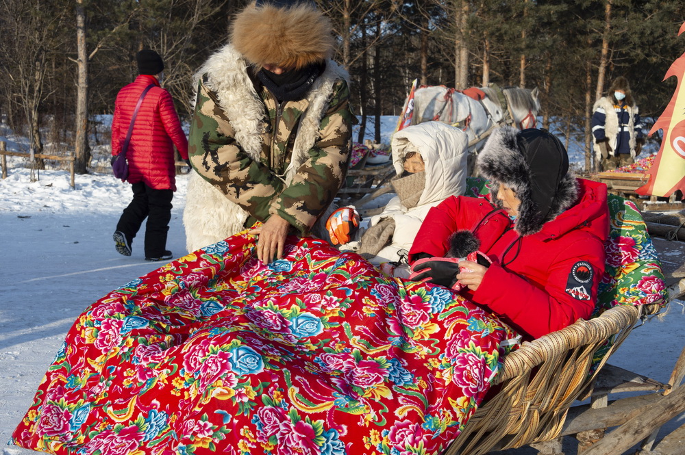 1月13日，在北極村，村民為乘坐馬拉爬犁的遊客蓋上花棉被。